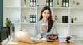 Working woman concept a female manager attending video conference and holding tablet, smatrphone and cup of coffee in office Royalty Free Stock Photo