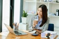 Working woman concept a female manager attending video conference and holding tablet, smatrphone and cup of coffee in office Royalty Free Stock Photo