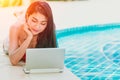 Working woman holiday using laptop computer at pool summer weekend
