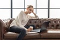 Working Woman sitting on leather sofa Royalty Free Stock Photo