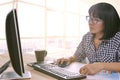 Working woman work on office computer and writing paper report