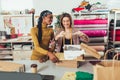 Working women at their store. They accepting new orders online and packing merchandise for customer