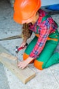 Working with wood in a garage. happy childhood. hardworking child hammering nail. teenage girl with hammer. little girl