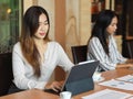 Workingwoman working on laptop in the office room with colleague