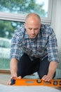Workman with air level flooring home Royalty Free Stock Photo