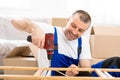 Workman In Blue Uniform Installing Shelf Using Electric Drill Indoor Royalty Free Stock Photo