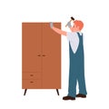 Workman cartoon character assembling wooden wardrobe using hammer isolated on white background