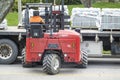 Toronto, Canada - April 28, 2020: Workman Driving a Red Forklift to Move a Pile of Concrete Patio Stones on a Suburban Street 3