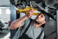 workman with equipment repairing car