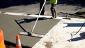 Workman finishes and smooths concrete surface on new sidewalk