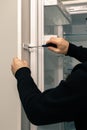 Workman fixes a kitchen facade on the door of the built-in refrigerator. Royalty Free Stock Photo