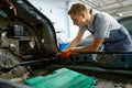 Workman fixing bolt during car body repair