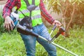 Workman holding lawn mower machine cutting grass