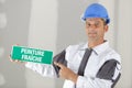 Workman holding sign saying wet paint in french