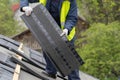 Workman install tile on roof of new house under construction