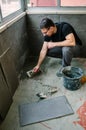 Workman laying tiles on a terrace