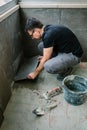 Workman laying tiles on a terrace