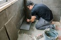 Workman laying tiles on a terrace