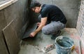 Workman laying tiles on a terrace