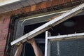 Workman removing old wooden window frame from brick wall Royalty Free Stock Photo