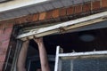 Workman removing part of an old wooden window from wall