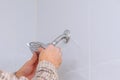 Workman repairing shower head in bathroom