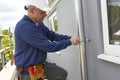 Workman Replacing Guttering On Exterior Of House