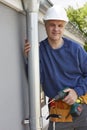 Workman Replacing Guttering On Exterior Of House