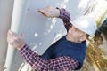 Workman replacing guttering on exterior house