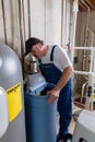 Workman replacing an old domestic water softener Royalty Free Stock Photo