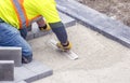 Workman in safety jacket preparing the foundation of patio pavers