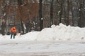Workman with shovel at work in winter clearing snow