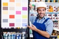 Workman showing stand with samples in shop