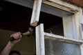 Workman smashing apart an old wooden window frame