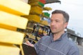 Workman by stack wood holding clipboard Royalty Free Stock Photo