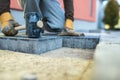Workman tamping down a new paving brick Royalty Free Stock Photo