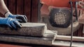 Workman using an angle grinder to cut a concrete block in a side