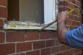 Workman using a crowbar to remove part of old wooden window frame