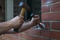 Workman using a hammer and chisel to remove old mortar