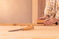 Workman using jack plane on wooden board. Crop faceless male carpenter smoothing wooden detail with jack plane