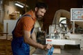 Workman using planer machine for production wooden materials specific size