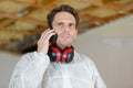 Workman wearing earmuffs receiving telephone call Royalty Free Stock Photo