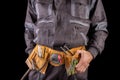 Workman in work clothes and tool belt. Production worker with a drill in his hand Royalty Free Stock Photo