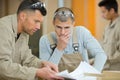 Workmen in duscussion while contemplating plans Royalty Free Stock Photo