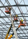 Workmen on high level hydraulic platforms