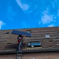 workmen put a solar panel on the roof Royalty Free Stock Photo