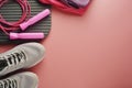 Workout concept, flat lay with copy space. Sport shoes, jumping rope, yoga clothes over pink background. Health, running workout, Royalty Free Stock Photo