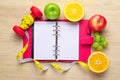 Workout and fitness dieting copy space diary. Healthy lifestyle concept. Apple, dumbbell, and measuring tape on rustic wooden Royalty Free Stock Photo