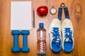 Workout and fitness dieting copy space diary. Healthy lifestyle concept. Dumbbell, water, expander hand ball on rustic wooden tab Royalty Free Stock Photo