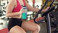 Workout in gym, slim woman drinking water while riding exercise bike, fitness Royalty Free Stock Photo